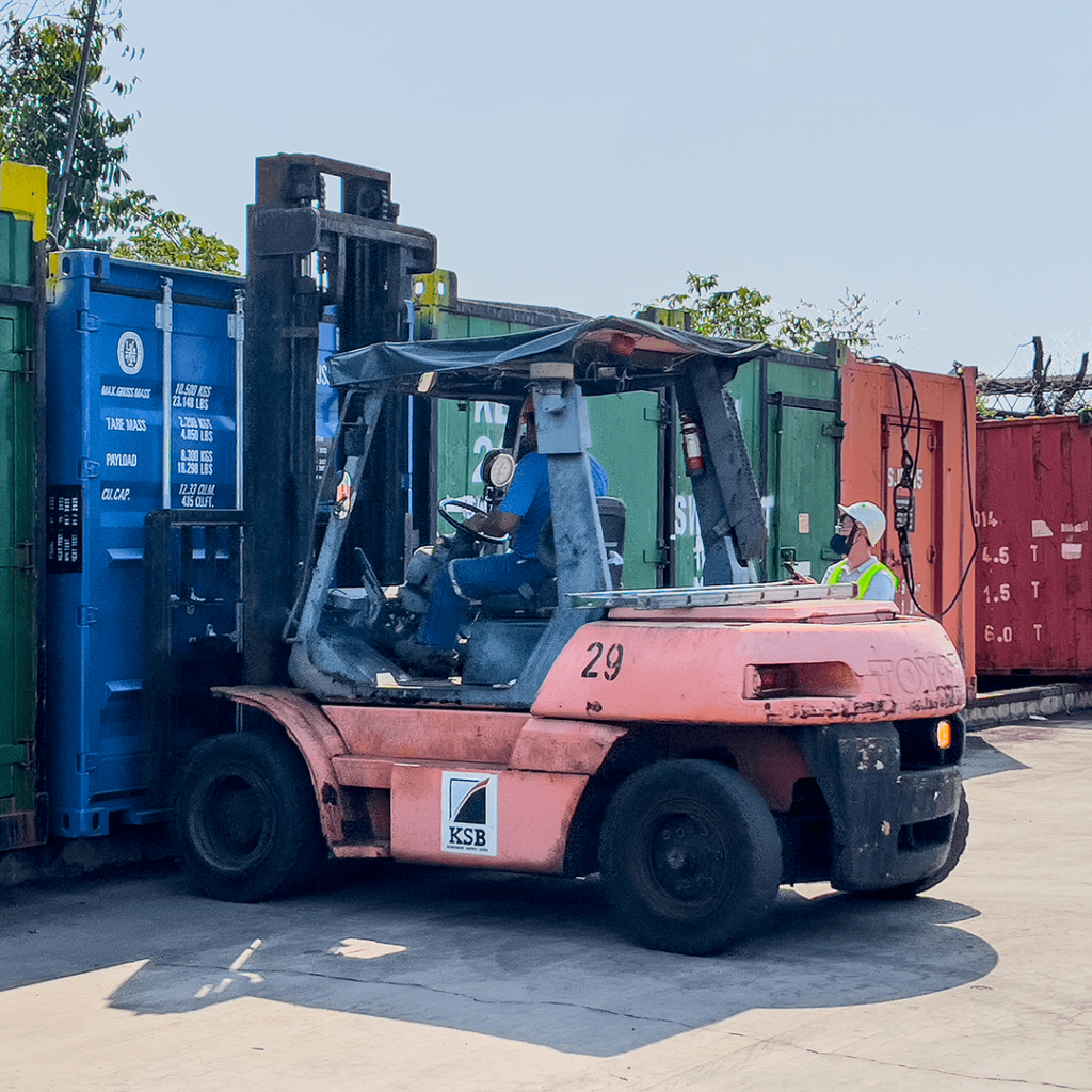 Forklift handling a container in a storage yard